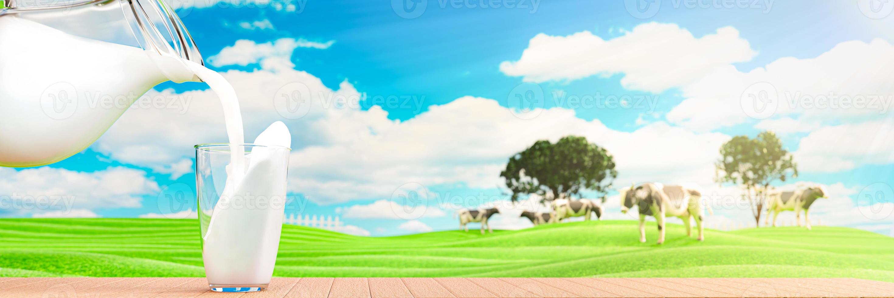 vierta la leche fresca de la jarra en un vaso transparente colocado sobre un piso de tablones de madera. las vacas de pradera verde brillante caminan libremente y disfrutan comiendo hierba. cielo azul claro con nubes blancas. representación 3d foto