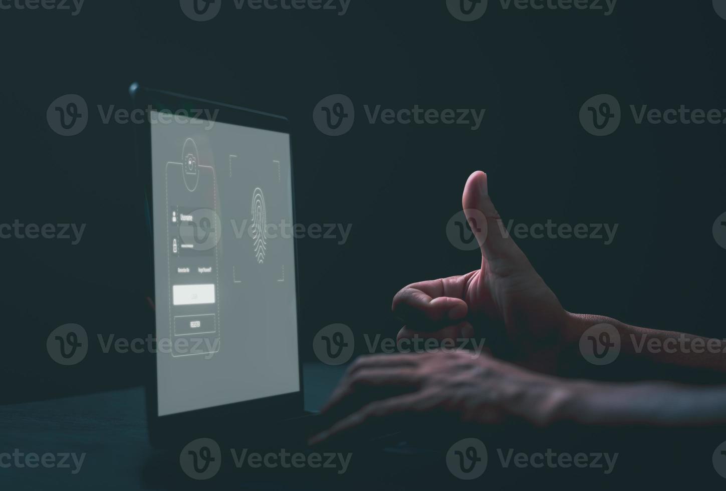Young businessman scanning his fingerprint to log in via a laptop computer, photo
