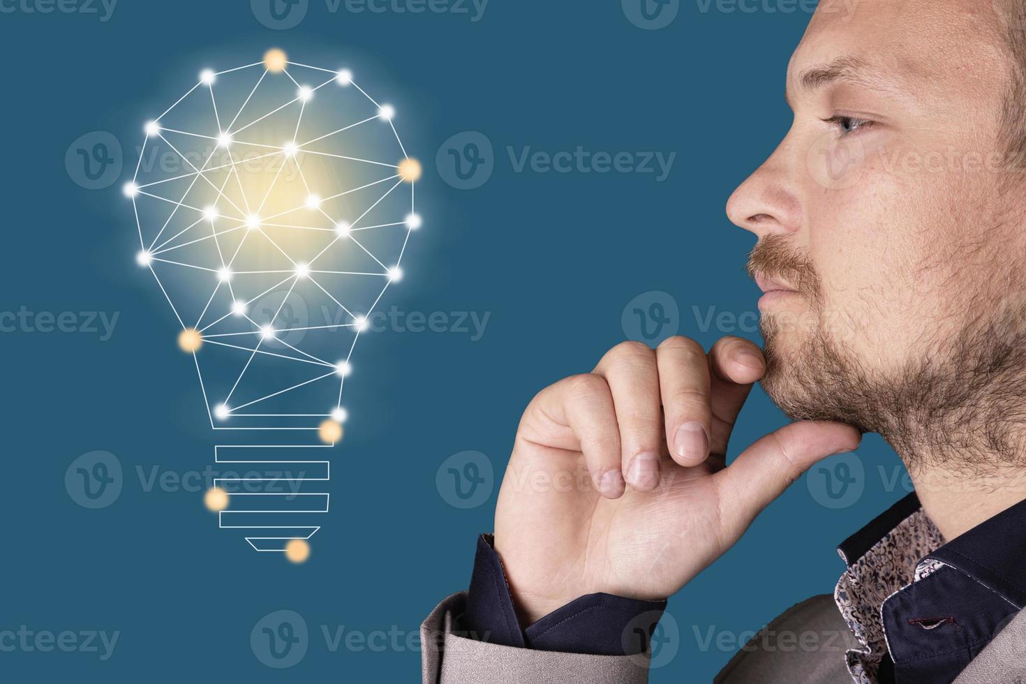 Business man looks at a bright light bulb in the wall in Atlantic blue. Concepts. photo