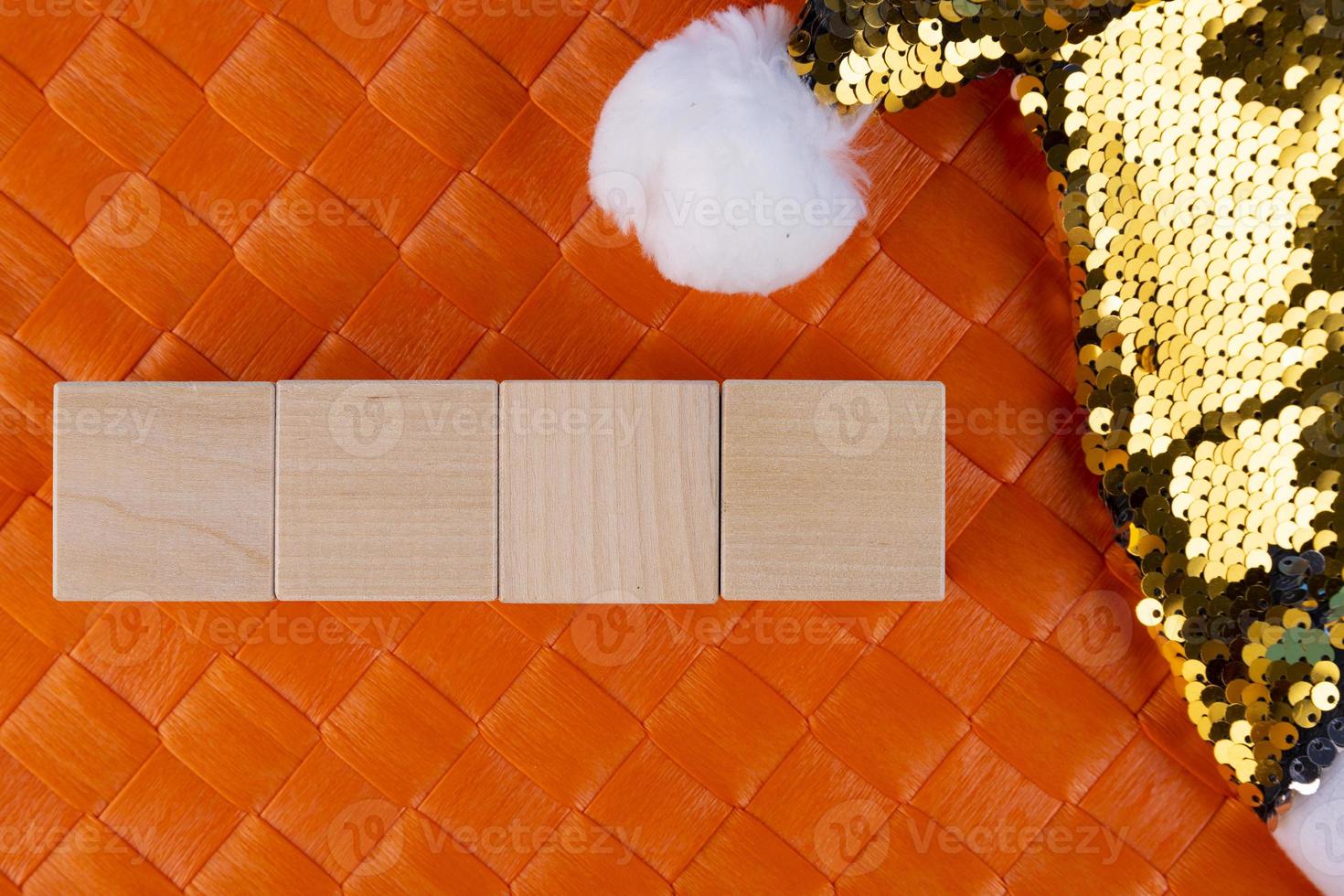 Concept for writing text from four letters or numbers on wooden cubes lying on an orange surface and with a Santa Claus hat. Copy space. photo