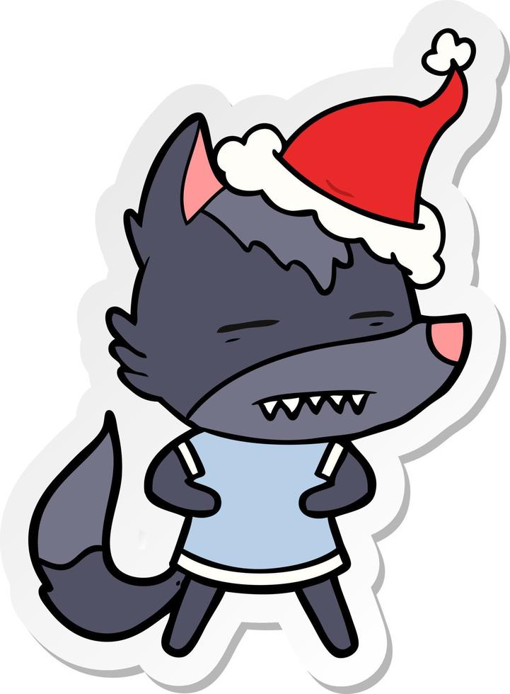 sticker cartoon of a wolf showing teeth wearing santa hat vector
