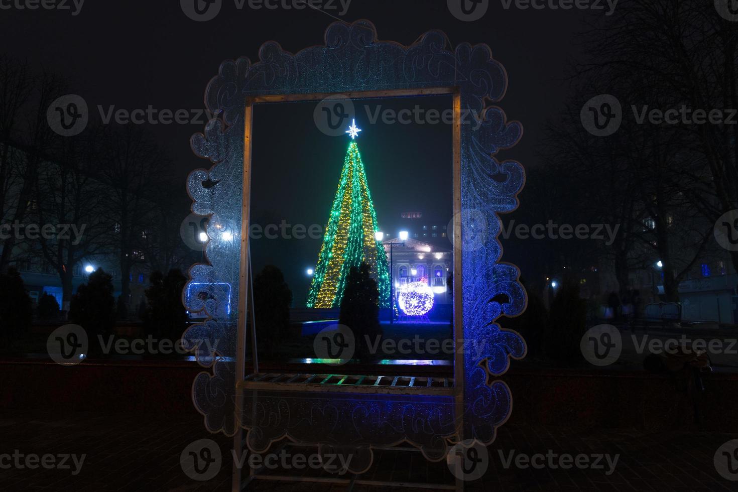 Christmas tree, New Year tree outside in the evening under the snow. photo