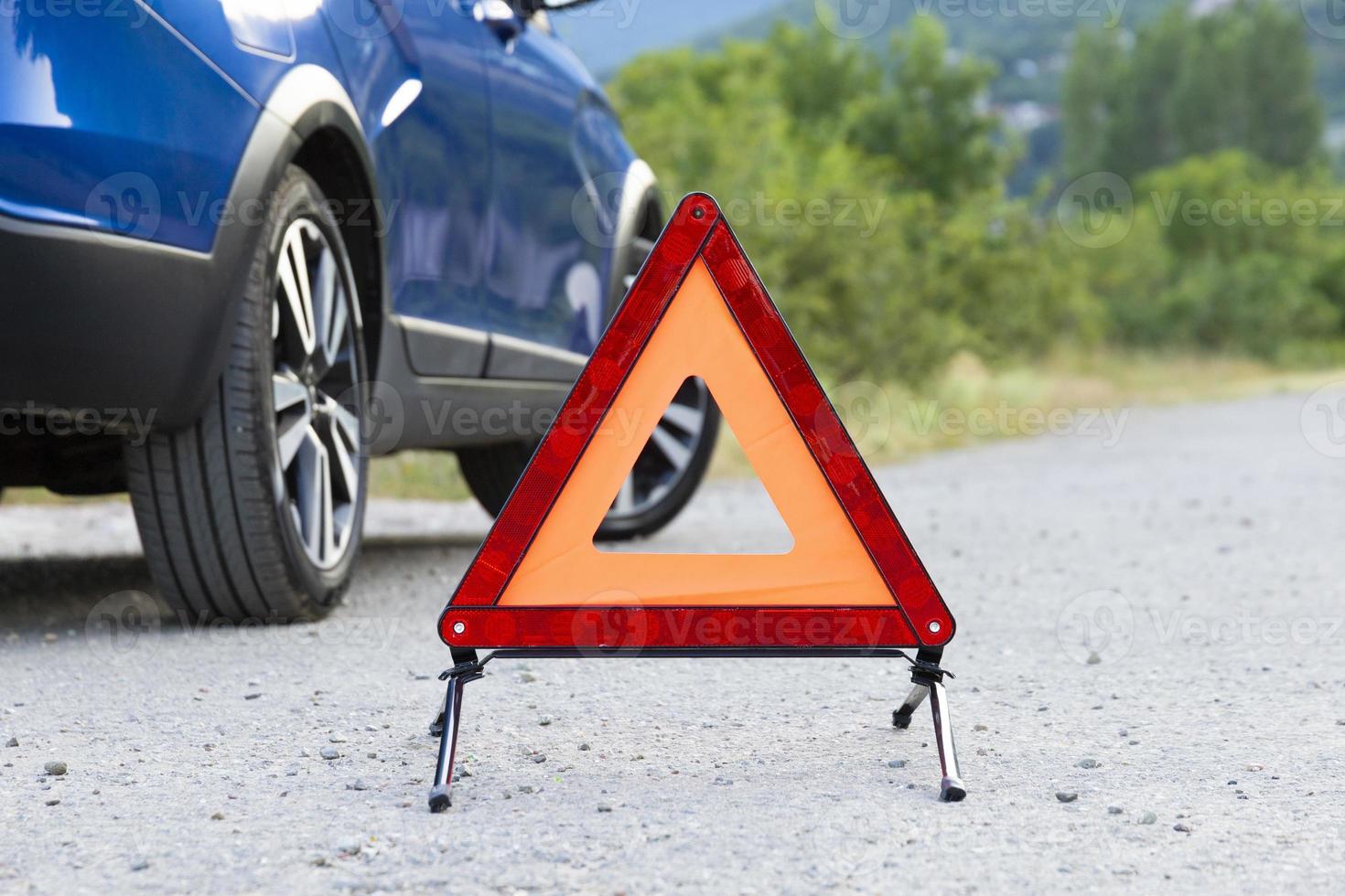 An emergency stop sign of a vehicle is installed on the road, next to the car. Copy space. photo