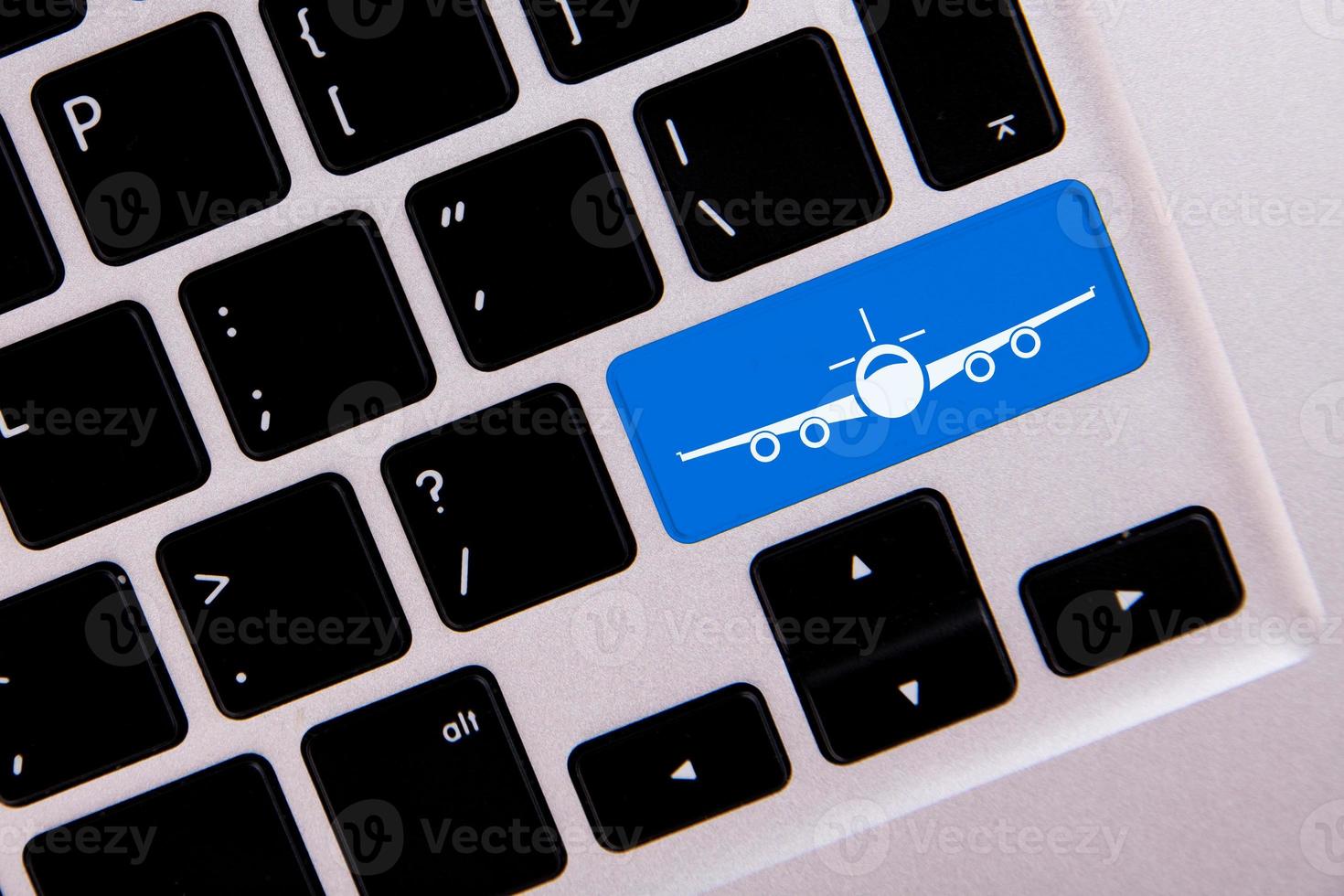 Travel concept. Keyboard of a modern laptop with a key in the form of an airplane, close up photo