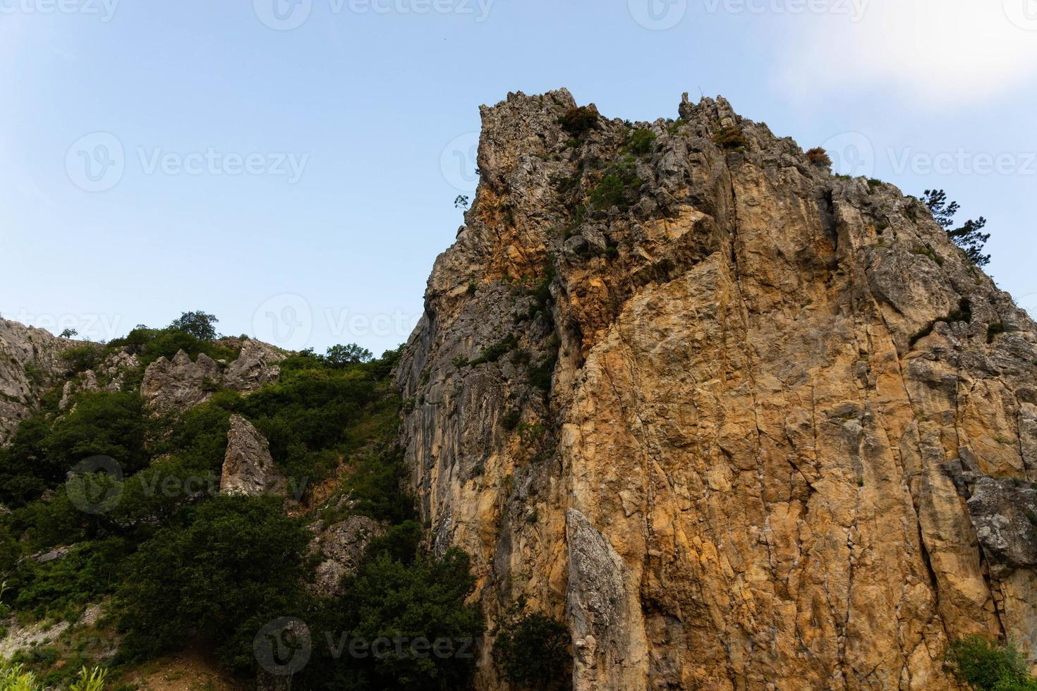 grandes acantilados salvajes de piedra caliza roja con escasa vegetación. foto