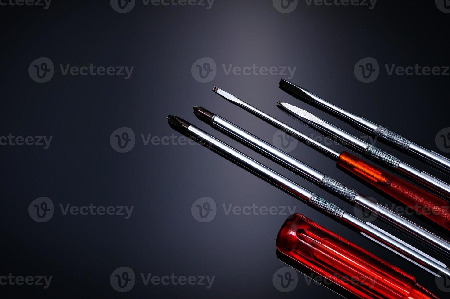 Screwdriver and center punch. Mechanic hand tools. Screwdriver sets with interchangeable blades. Mobile tools set. Tools set on black background. Screwdriver with orange grip handle. Repair tools. photo