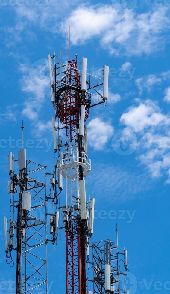 Telecommunication tower with blue sky and white clouds background. Antenna on blue sky. Radio and satellite pole. Communication technology. Telecommunication industry. Mobile or telecom 4g network. photo