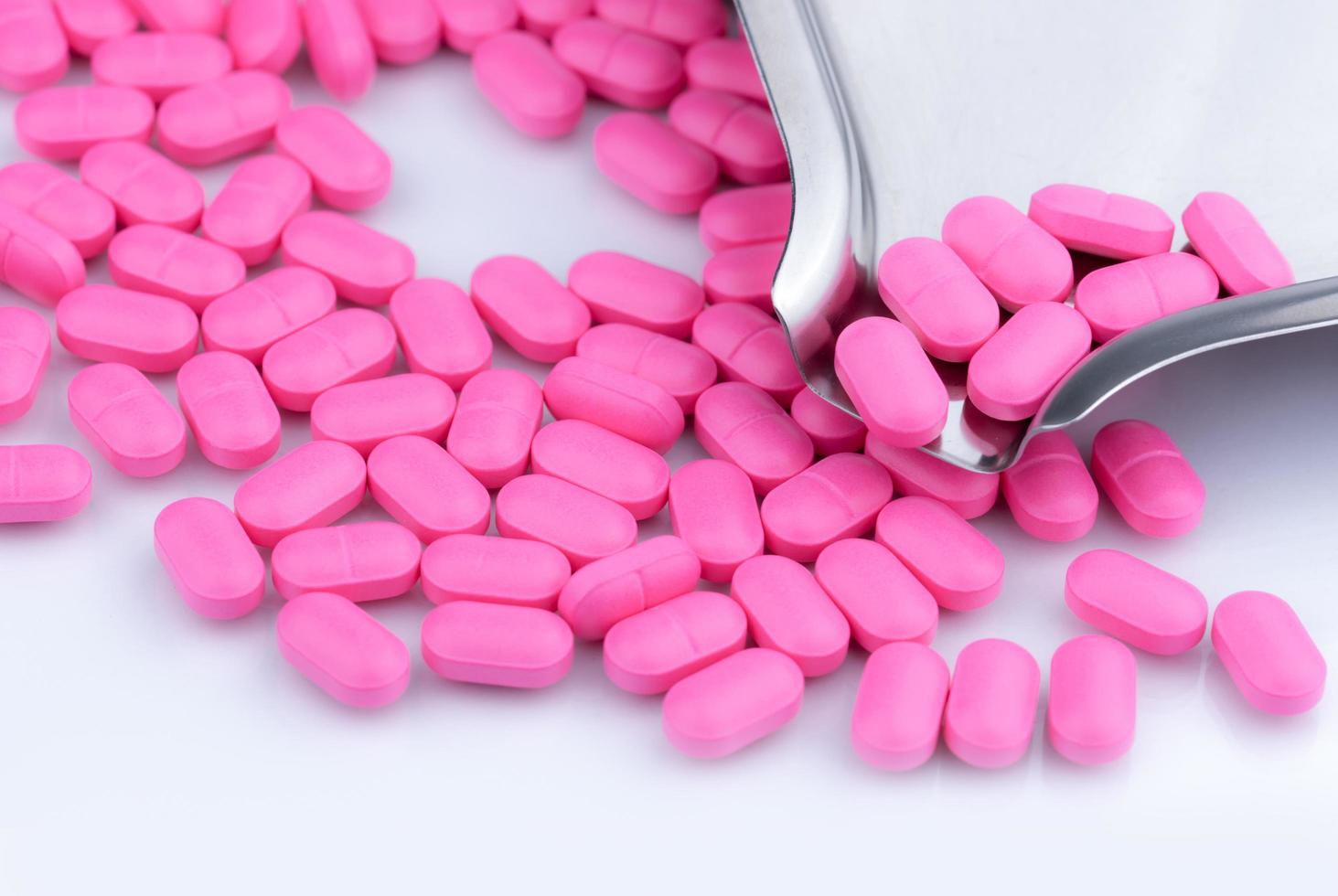 Top view of pink tablets pills on stainless steel drug tray. Pharmaceutical industry. Pharmacy drugstore products. Drug count. Medication use in hospital. Pharmacology. Prescription drugs. Healthcare. photo