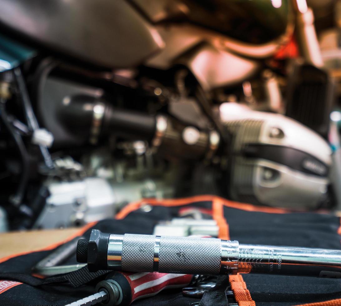 Tool on the table with single cylinder head cover of a motorcycle photo