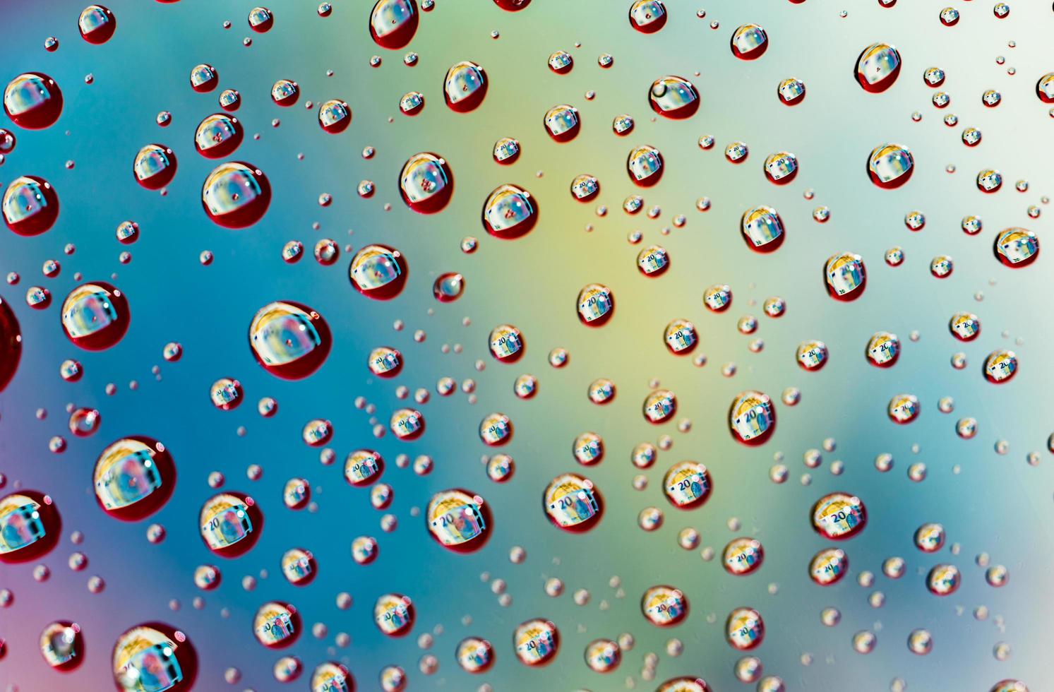 Macro shot detail reflection of 20 Euro banknote in water drops. Colorful water drops background photo