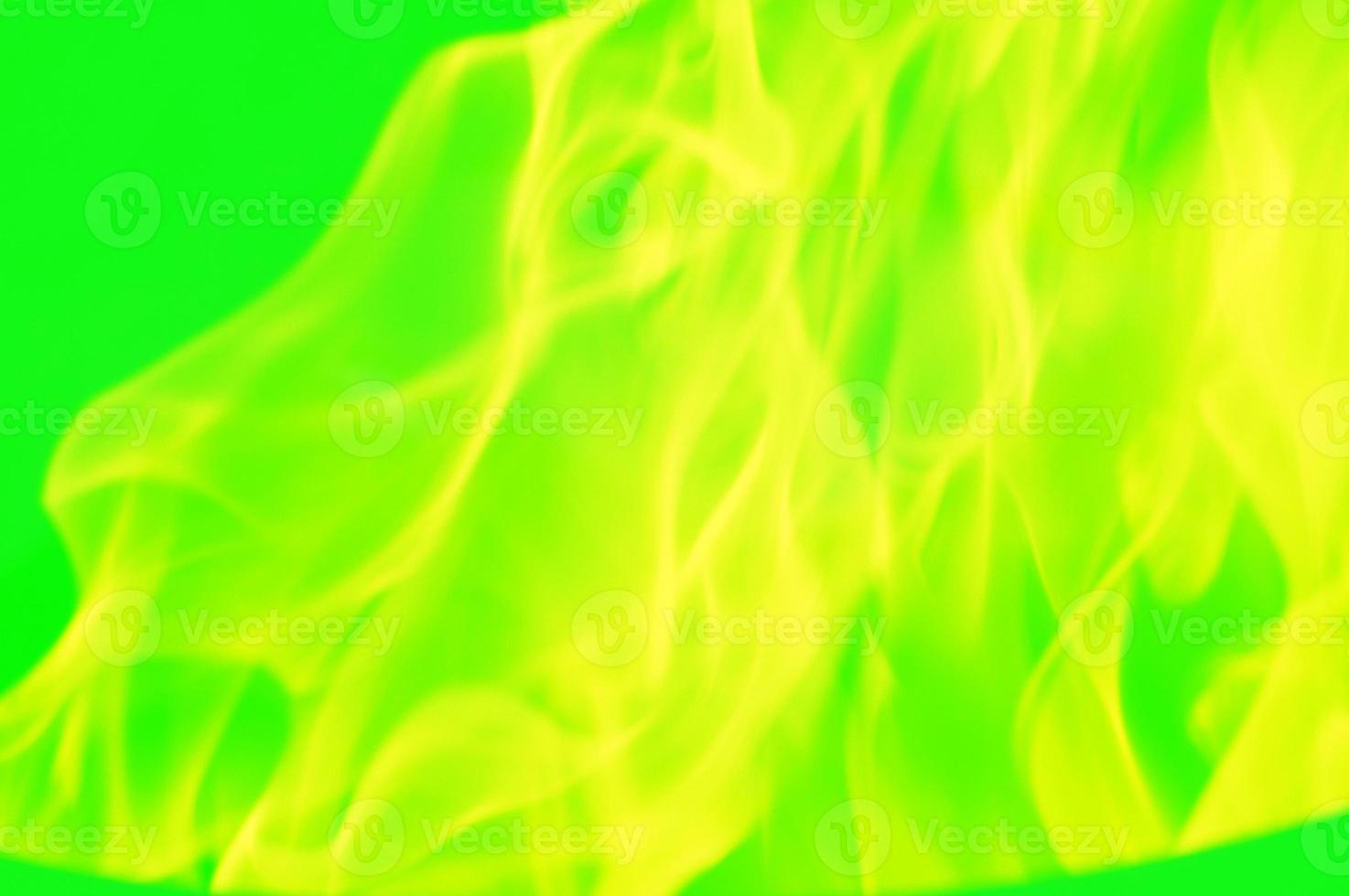 Yellow abstract pattern, glare of light, flames, smoke on a green background. photo