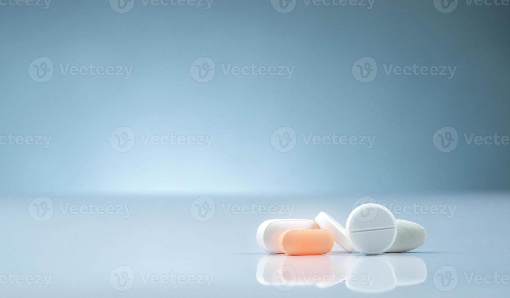 Pharmacy drugstore product. Pile of orange and white tablets pill on gradient background. Different size and shape tablets pills. Pharmaceutical industry. Medicine in hospital. Retail drug market. photo