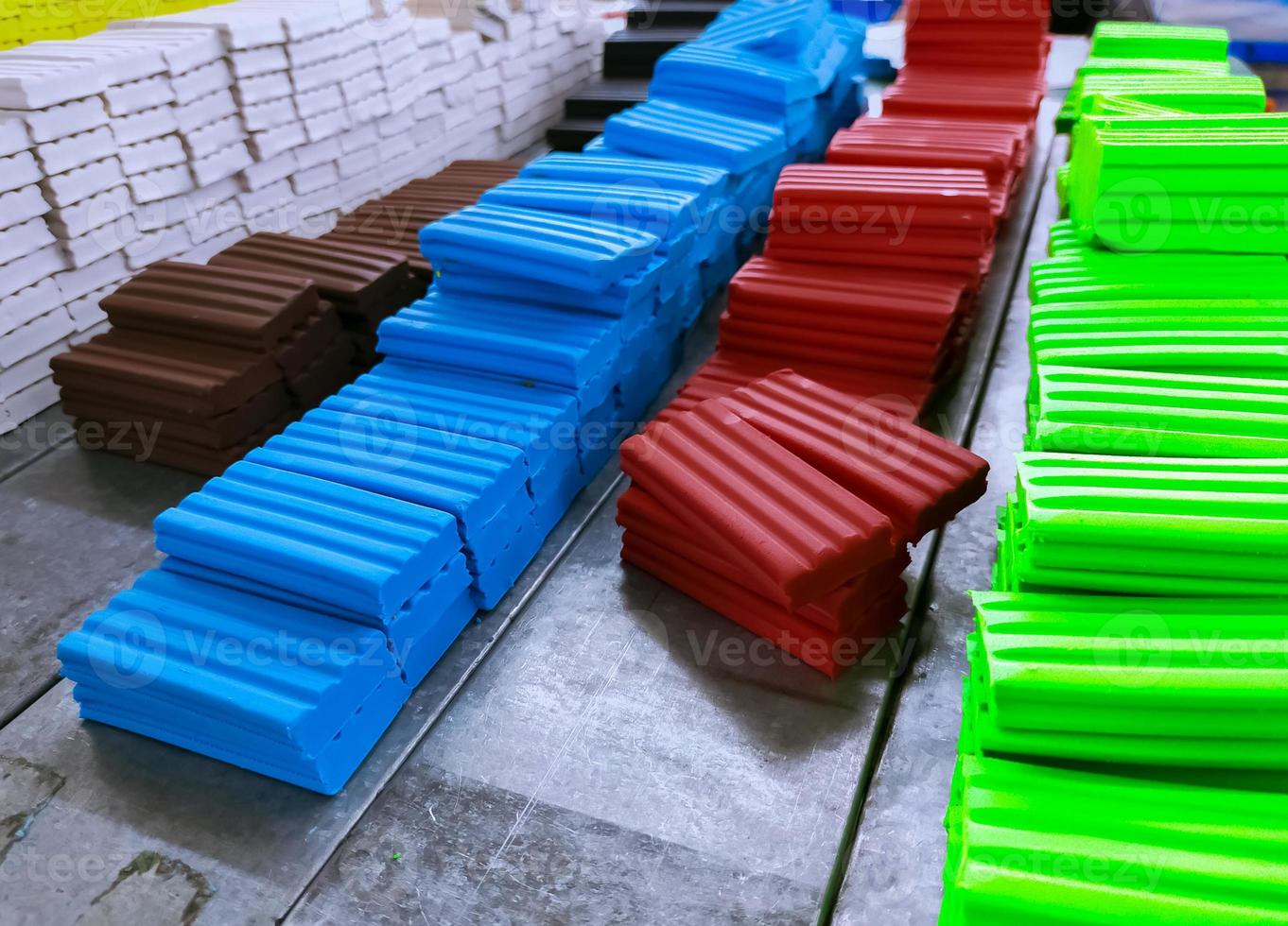 Heap of plasticine at production line in factory. Multi-colored modeling clay. Plasticine production industry. Modeling clay material for kids art education. Plasticine for preschool play dough. photo