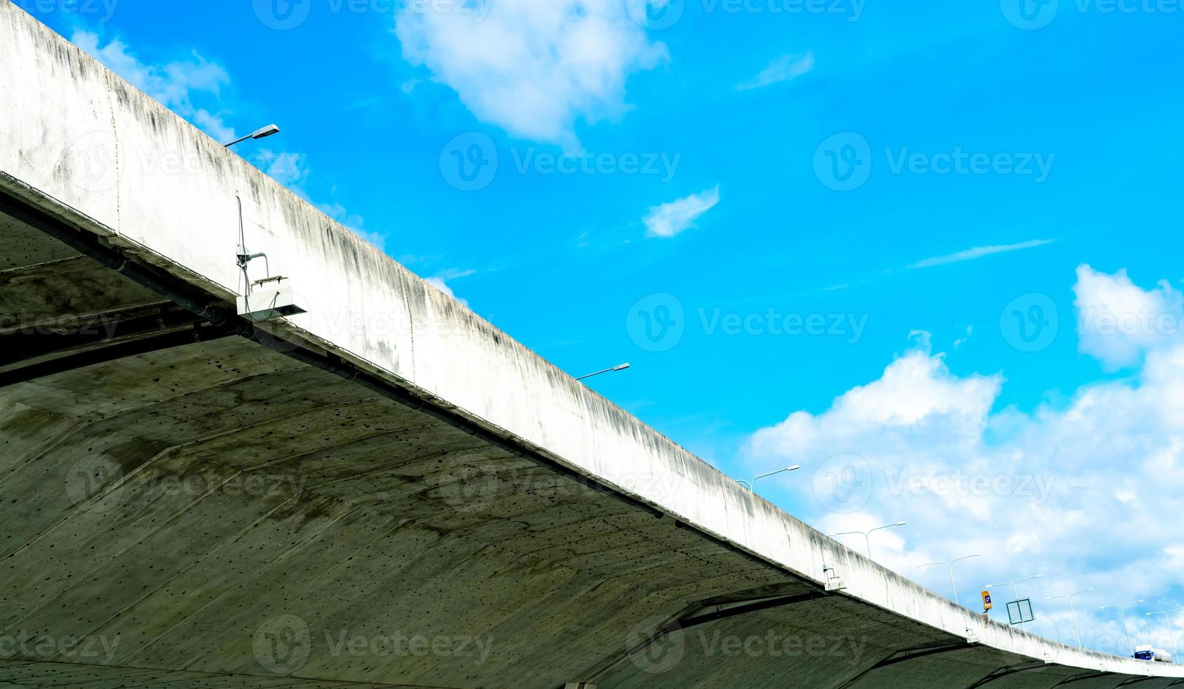 Bottom view of elevated concrete highway. Overpass concrete road. Road flyover structure. Modern motorway. Transportation infrastructure. Concrete bridge engineering construction. Bridge architecture. photo