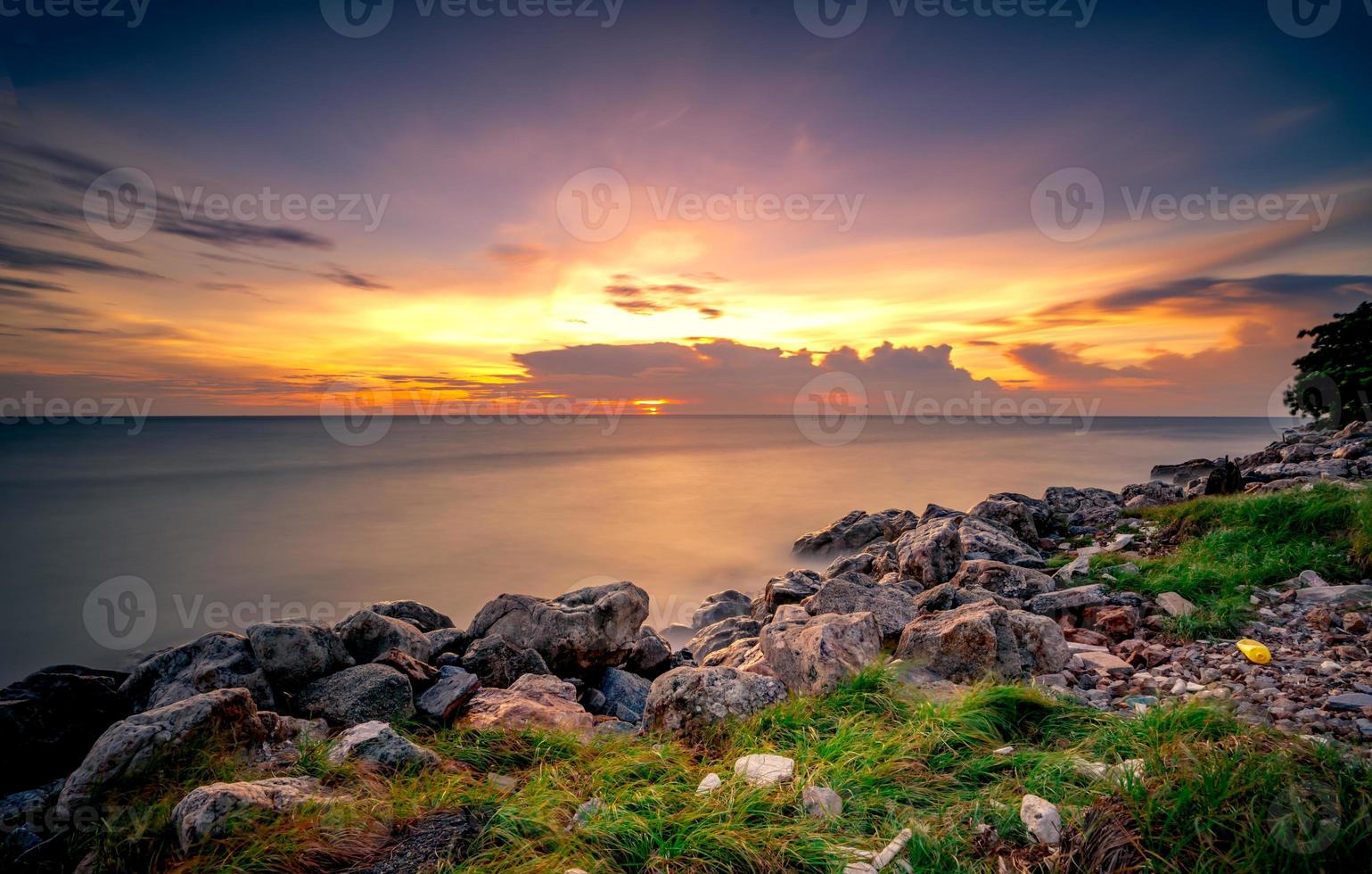 Rocks on stone beach at sunset. Beautiful beach sunset sky. Twilight sea and sky. Tropical sea at dusk. Dramatic sky and clouds. Calm and relax life. Nature landscape. Tranquil and peaceful concept. photo