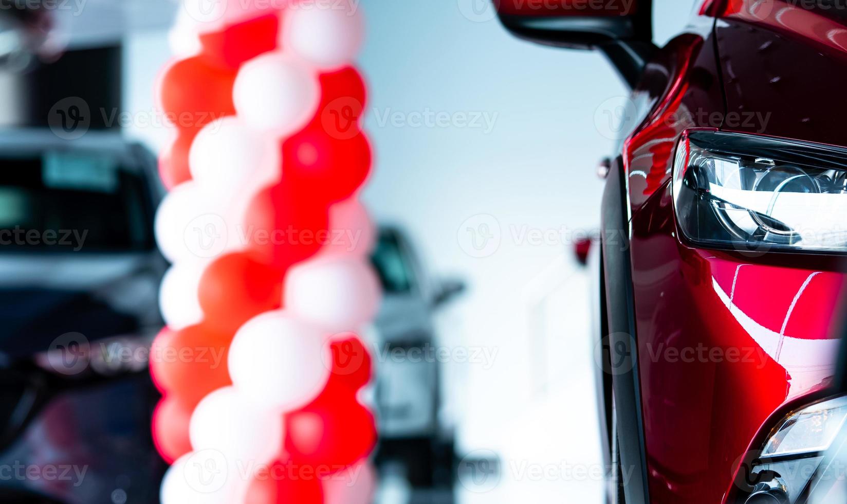 Closeup headlights of red SUV car. New luxury SUV car parked in modern showroom with sale promotion events. Car dealership office. Electric car business. Automobile leasing. Automotive industry. photo