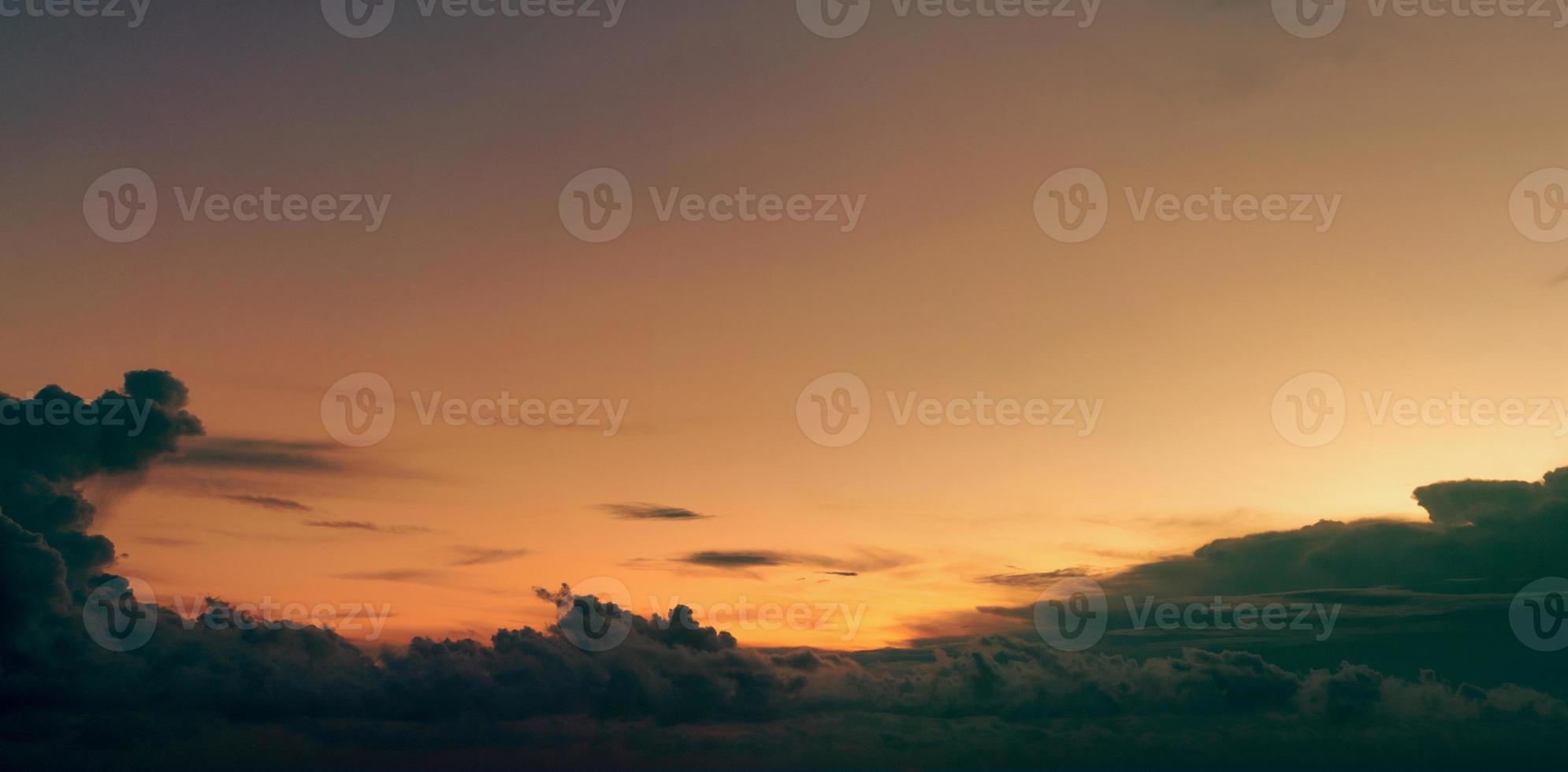 Beautiful golden sunset sky and dark clouds. Sky in the evening with yellow and orange light from the sun. Peaceful and tranquil background. Beauty in nature. Abstract background for inspiration quote photo