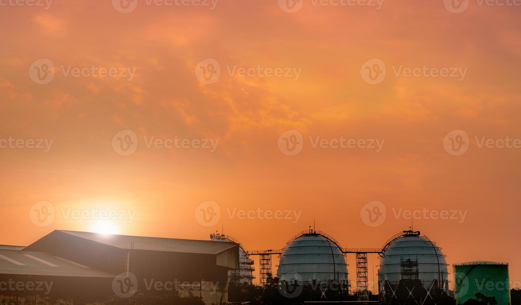 Industrial gas storage tank. LNG or liquefied natural gas storage tank. Red and orange sunset sky. Spherical gas tank in petroleum refinery. Above-ground storage tank. Natural gas storage industry. photo