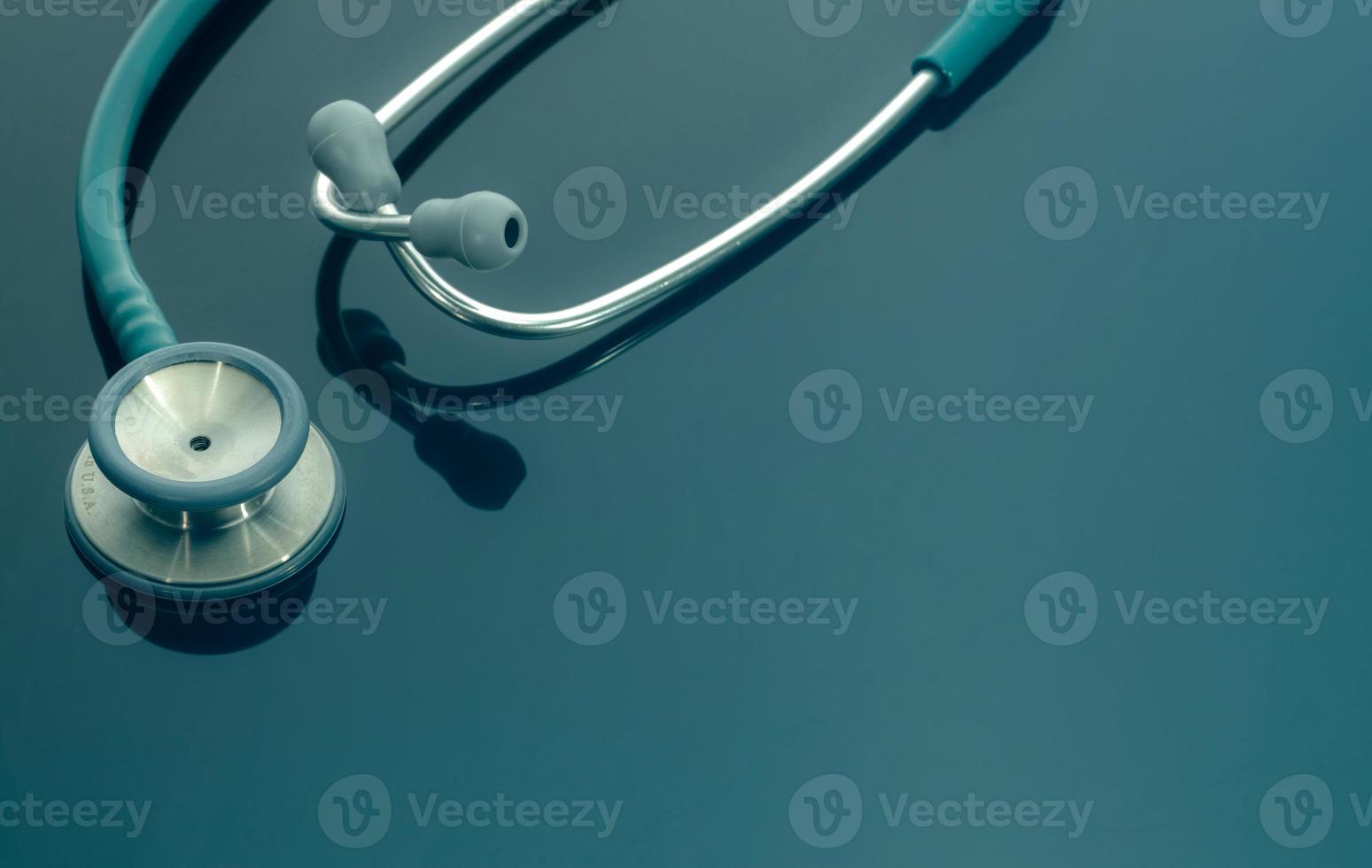 Closeup green stethoscope on doctor table or nurse desk. Health checkup or health insurance concept. Cardiology doctor equipment. Medical healthcare background. Physician tool for patient diagnosis. photo