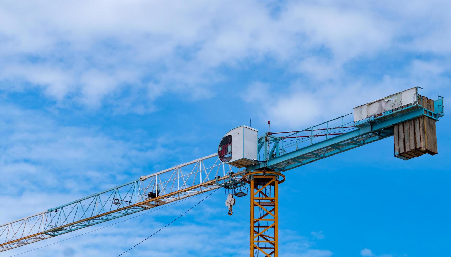 sitio de construcción con grúa y edificio. sector inmobiliario. equipo de elevación de carrete de uso de grúa en el sitio de construcción. edificio de vidrio y hormigón. trabajo de grúa de construcción contra el cielo del atardecer. foto