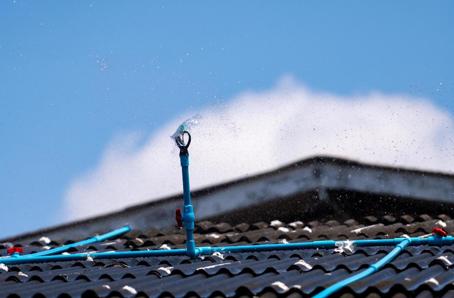 Instale el rociador en el techo de tejas para reducir la temperatura dentro del edificio de la casa. aspersor con sistema automático. Riego del sistema de riego doméstico. servicio de mantenimiento del sistema de rociadores. foto