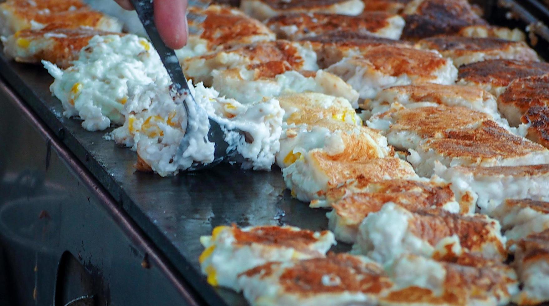 Khanom Babin. Thai desserts. Coconut pancake. Thai food sellers use spoon to flip coconut pancake on hot stove. Thai candy. Freshly made dessert at street food in Thailand. Thai style pancakes. photo