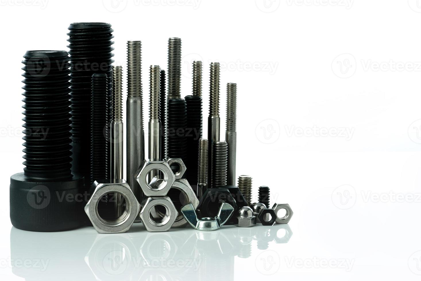 Metal bolts and nuts on white background. Fasteners equipment. Hardware tools. Stud bolt, hex nuts, and hex head bolts in workshop. Threaded fastener use in automotive engineering. Hexagonal bolt. photo