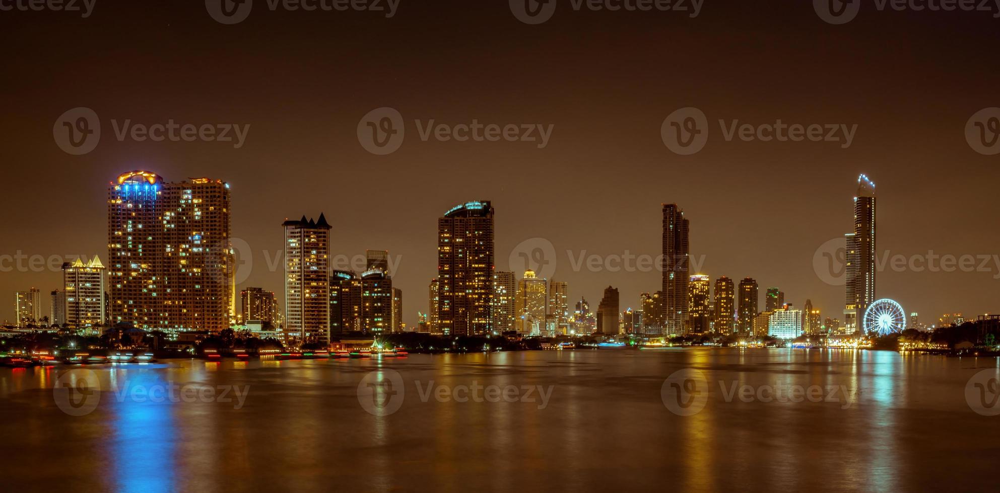 Cityscape of modern building near the river in the night. Modern architecture office building. Skyscraper with evening sky. Night photography of riverfront building. Condominium open light in night. photo