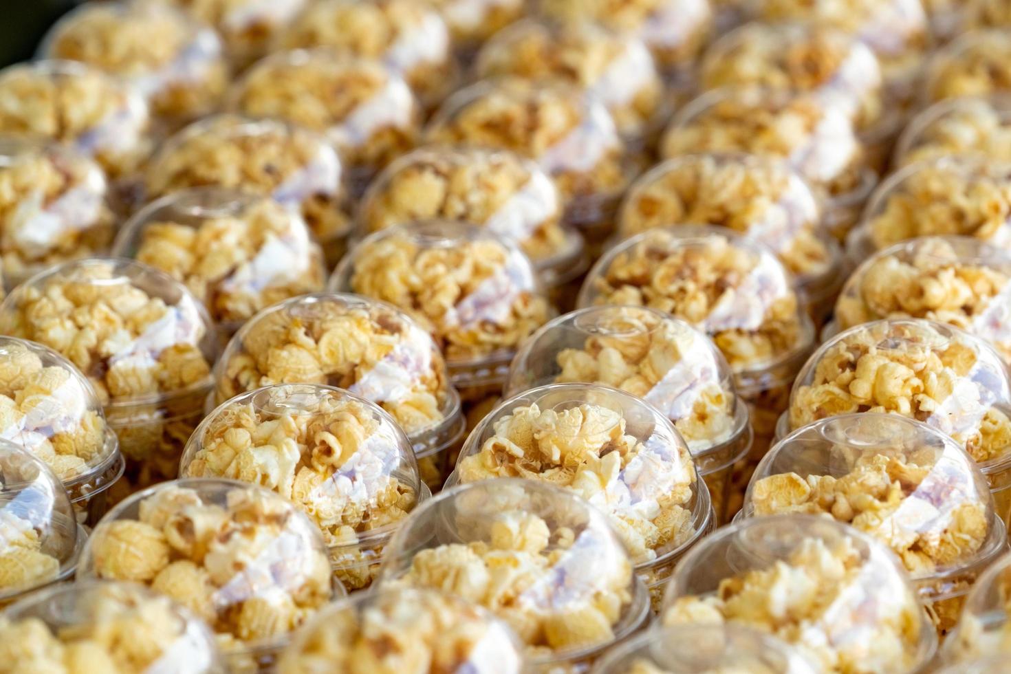 Popcorn in a plastic cup is beautifully placed. Unhealthy food or snack concept. Tasty salty popcorn. Carbohydrates food. Junk food. Popcorn on plastic glass for sale or donate for charity event. photo