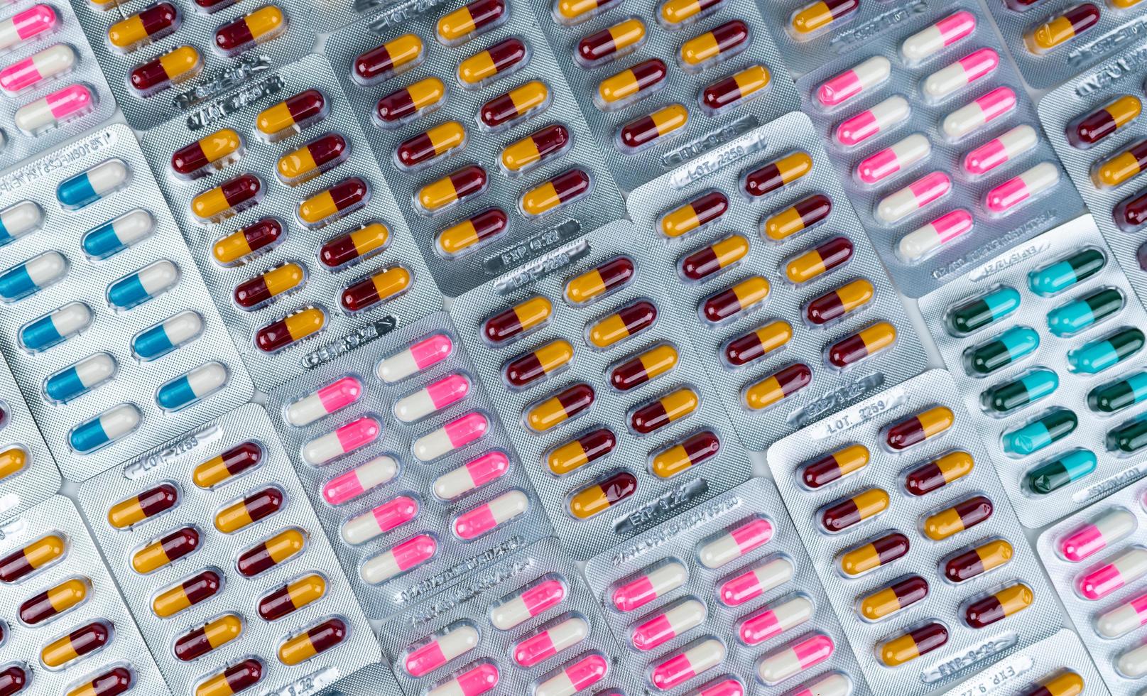 Top view of colorful antibiotic capsule pills in blister pack. Antibiotic drug resistance. Pharmaceutical industry. Pharmacy drug store background. Global health care.  Antimicrobial capsule. photo