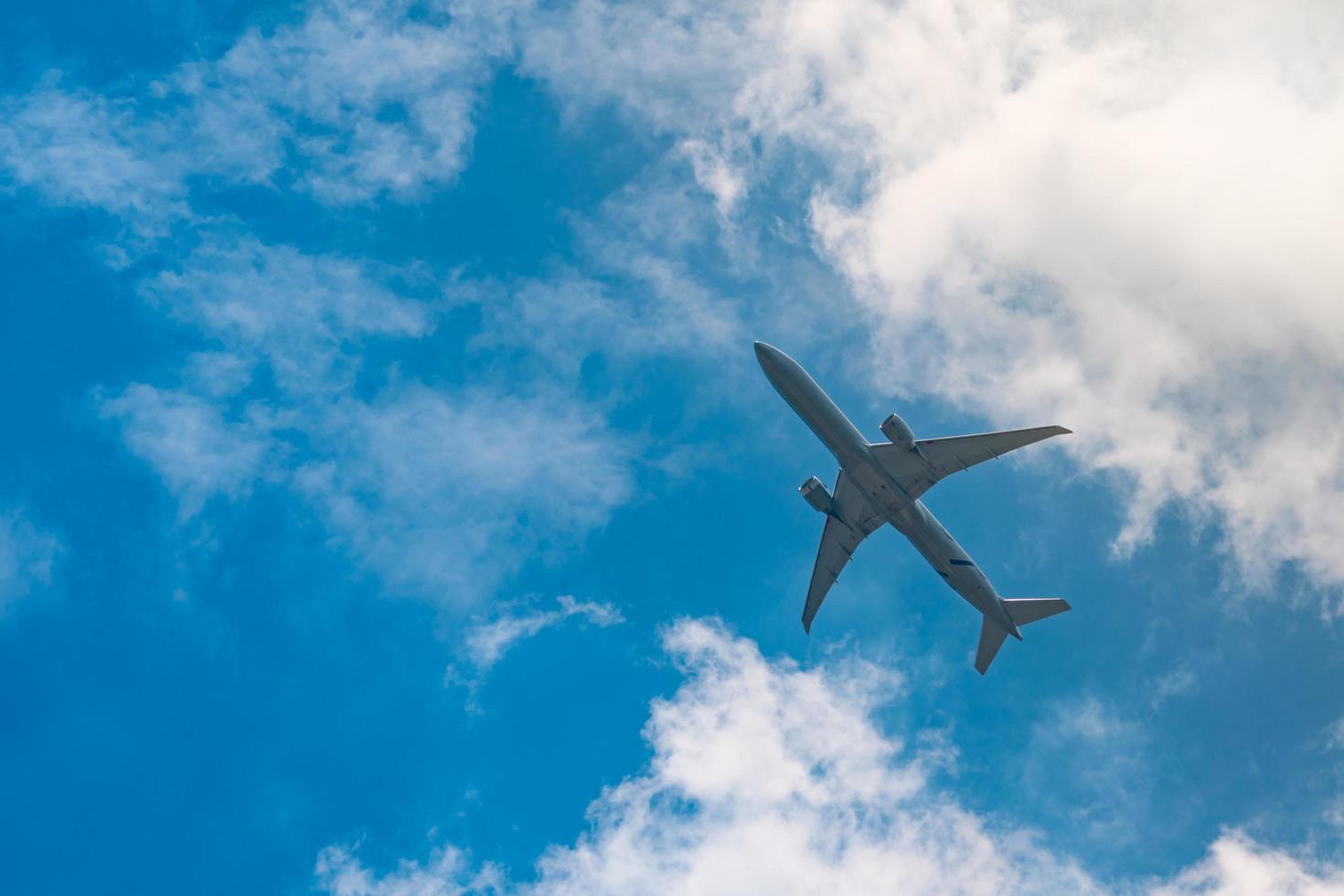 aerolínea comercial volando sobre cielo azul y nubes blancas esponjosas. bajo la vista del vuelo del avión. avión de pasajeros después de despegar o ir al vuelo de aterrizaje. viajes de vacaciones al extranjero. transporte aéreo. foto