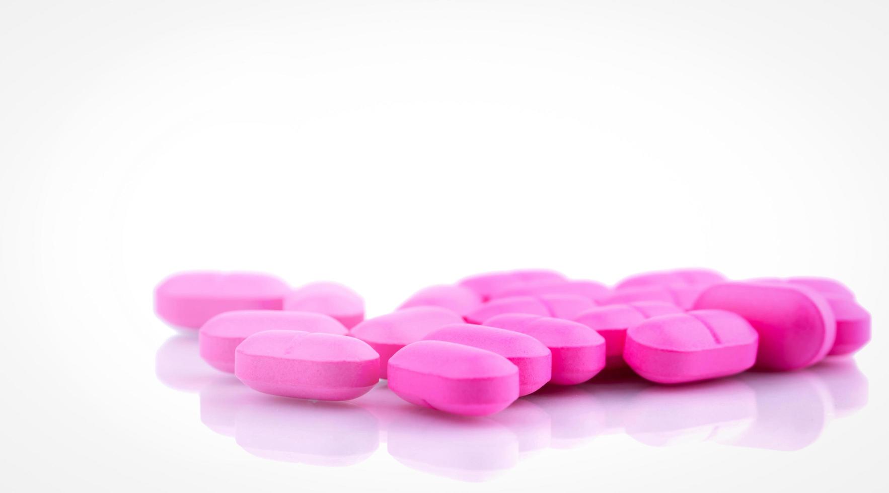 Pink tablets pills on white background. Pharmacy drugstore background. Pharmaceutical industry. Pink tablets for treatment love problem. Drug use in hospital. Health budget concept. Healthcare concept photo