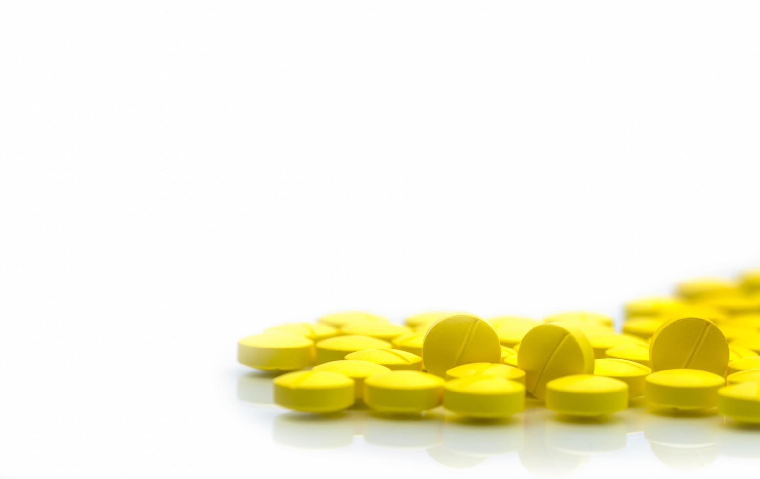 Yellow tablets pills isolated on white background with copy space. Pile of medicine. Painkiller tablets pills. photo