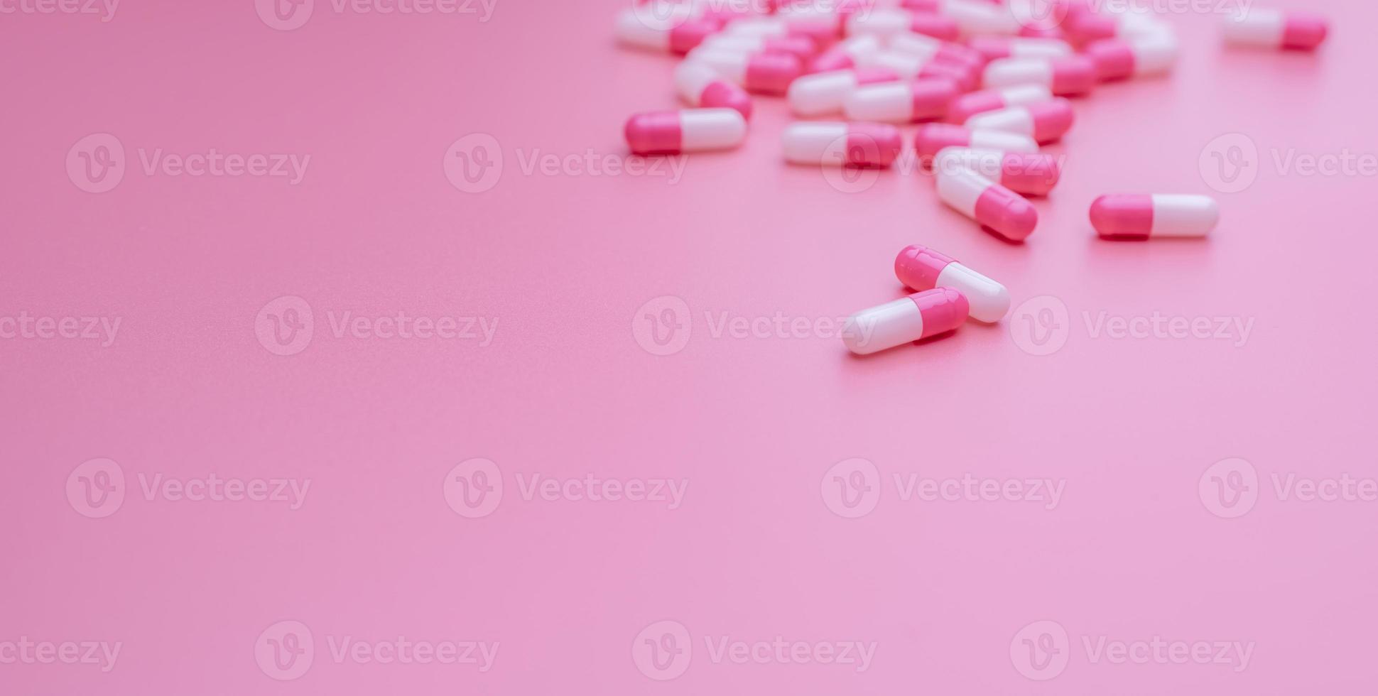 píldoras de cápsula antibiótica de color rosa-blanco sobre fondo rosa. resistencia a los antibióticos, uso excesivo y concepto de uso indebido. industria farmacéutica. medicamentos con receta. Pastillas para el amor y la felicidad. cuidado de la salud. foto