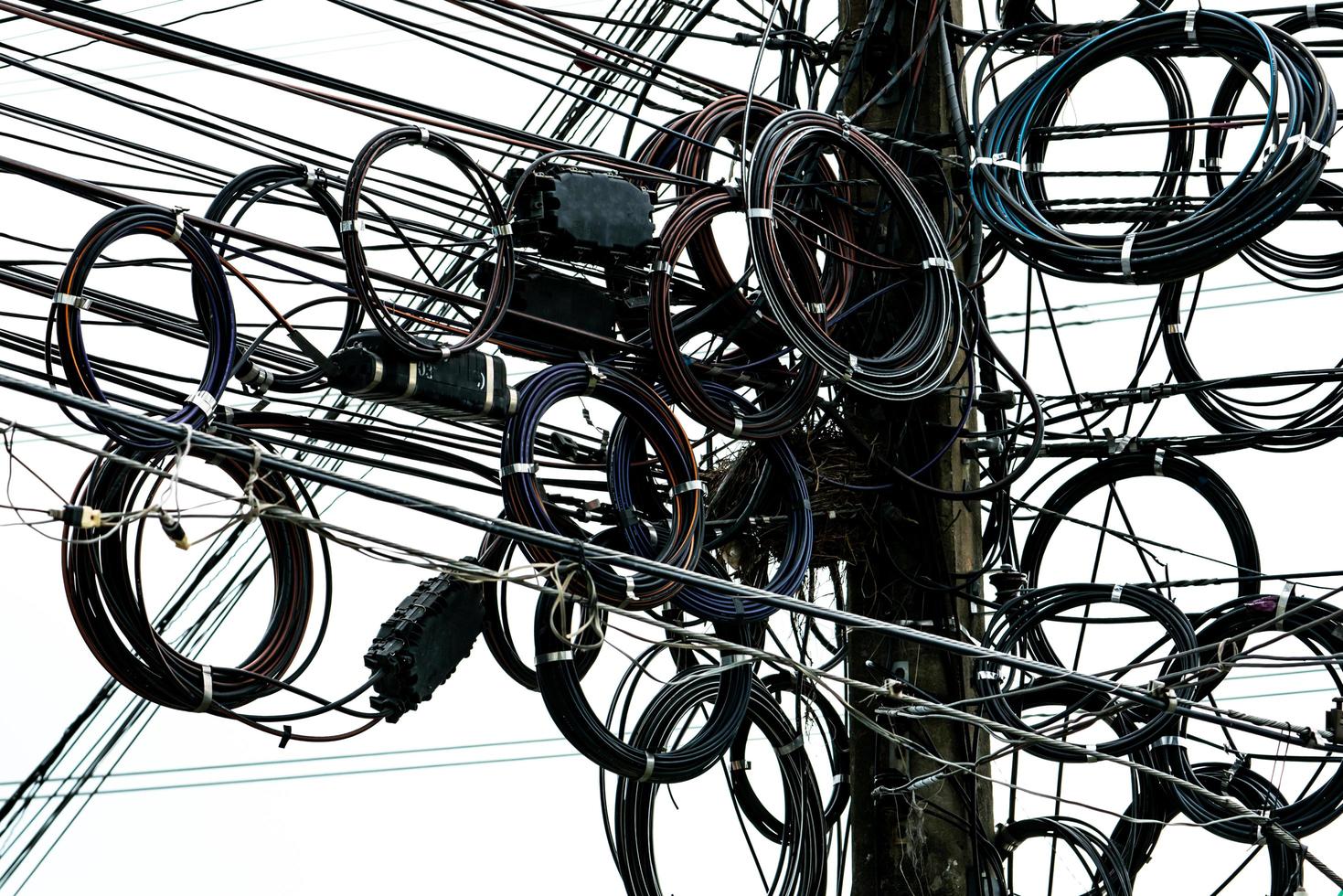 cables eléctricos enredados en poste eléctrico urbano. desorganizado y desordenado para el concepto de gestión de la organización foto