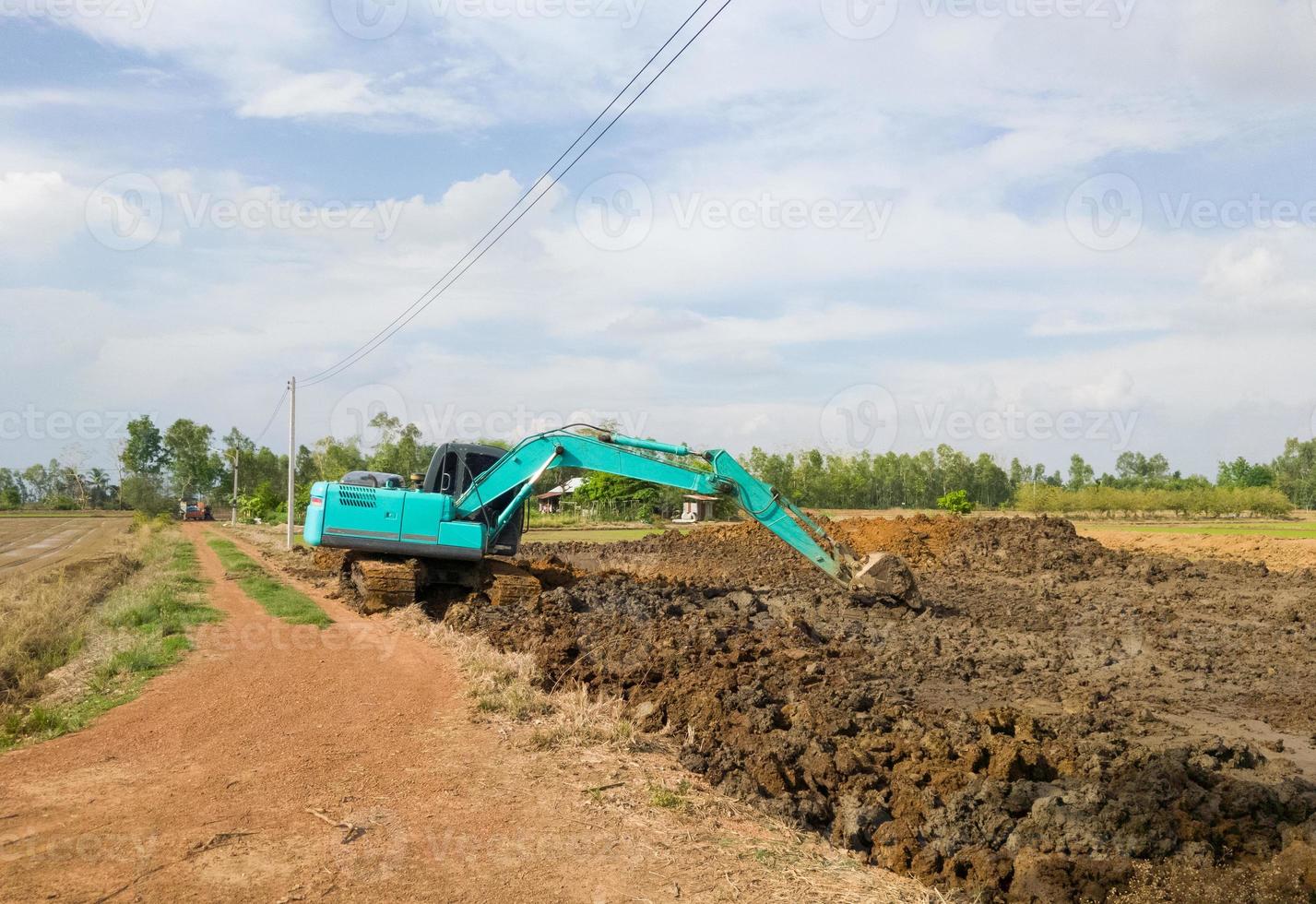 The modern excavator is working on earthwork for digging the ponds. photo