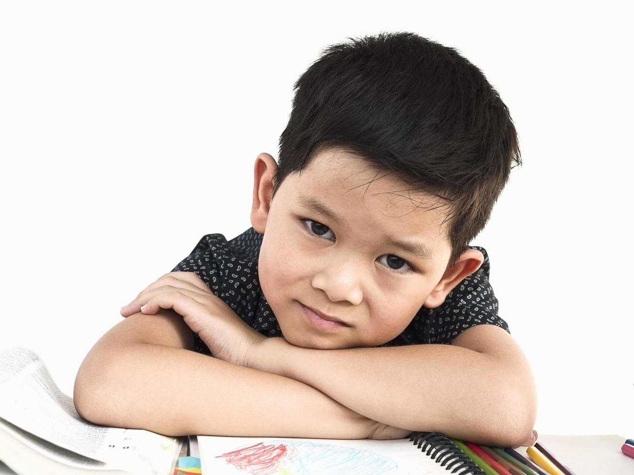 Asian kid is happily preparing for reading a book, isolated over white photo