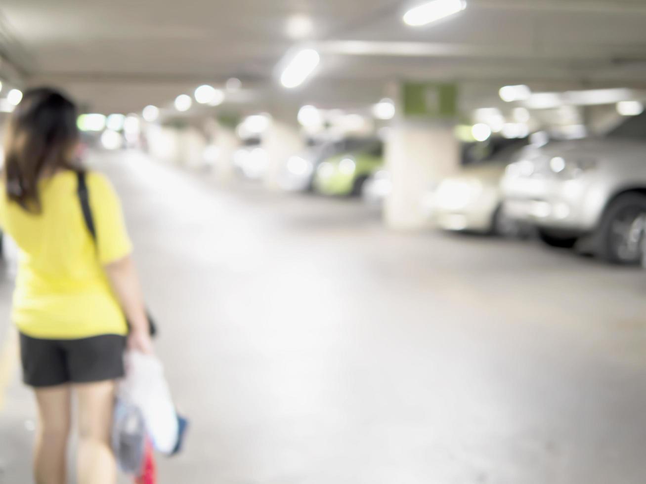 Blurred photo of a woman is walking dangerously in a car parking area