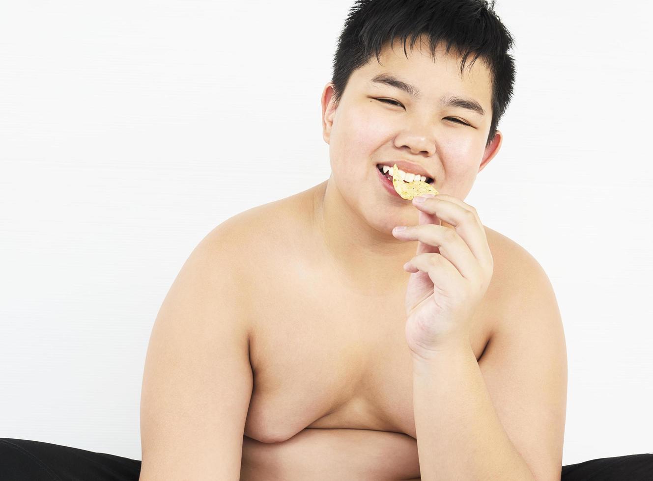 Fat boy is happily eating chip photo