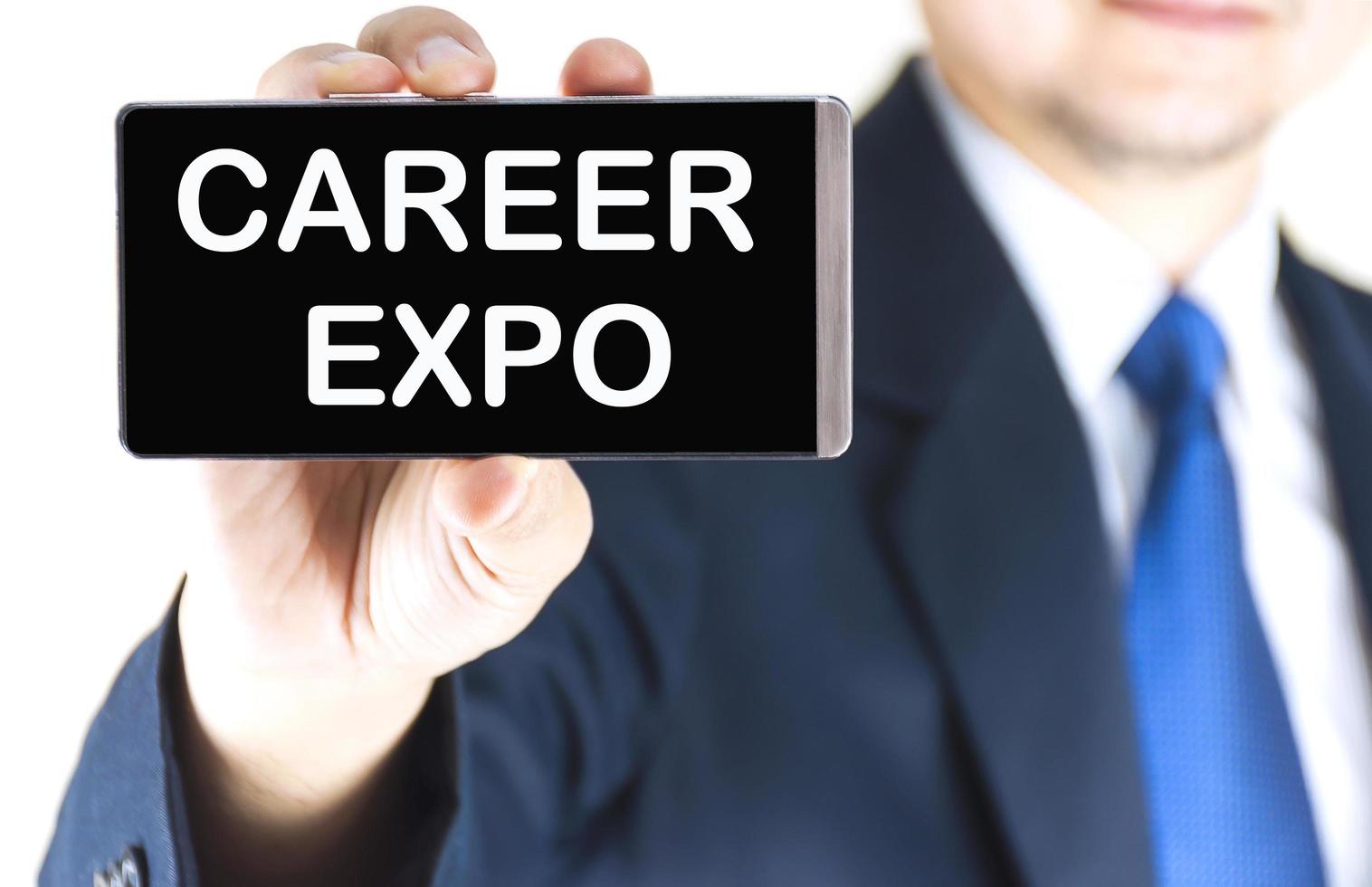 CAREER EXPO word on mobile phone screen in blurred young businessman hand over white background, business concept photo