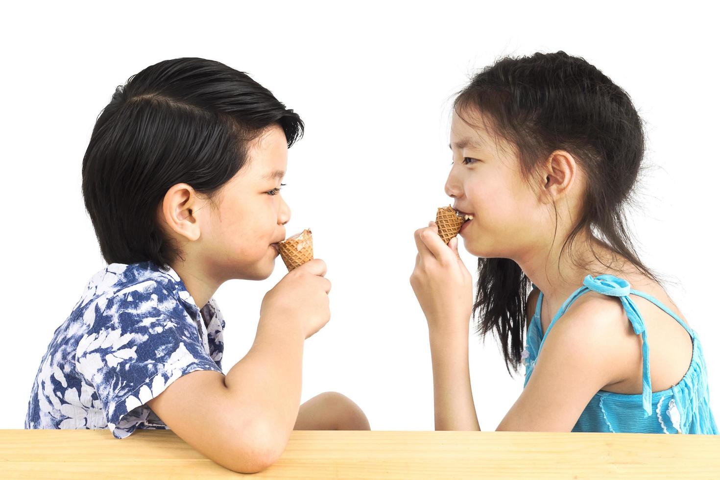 los niños asiáticos están comiendo helado foto