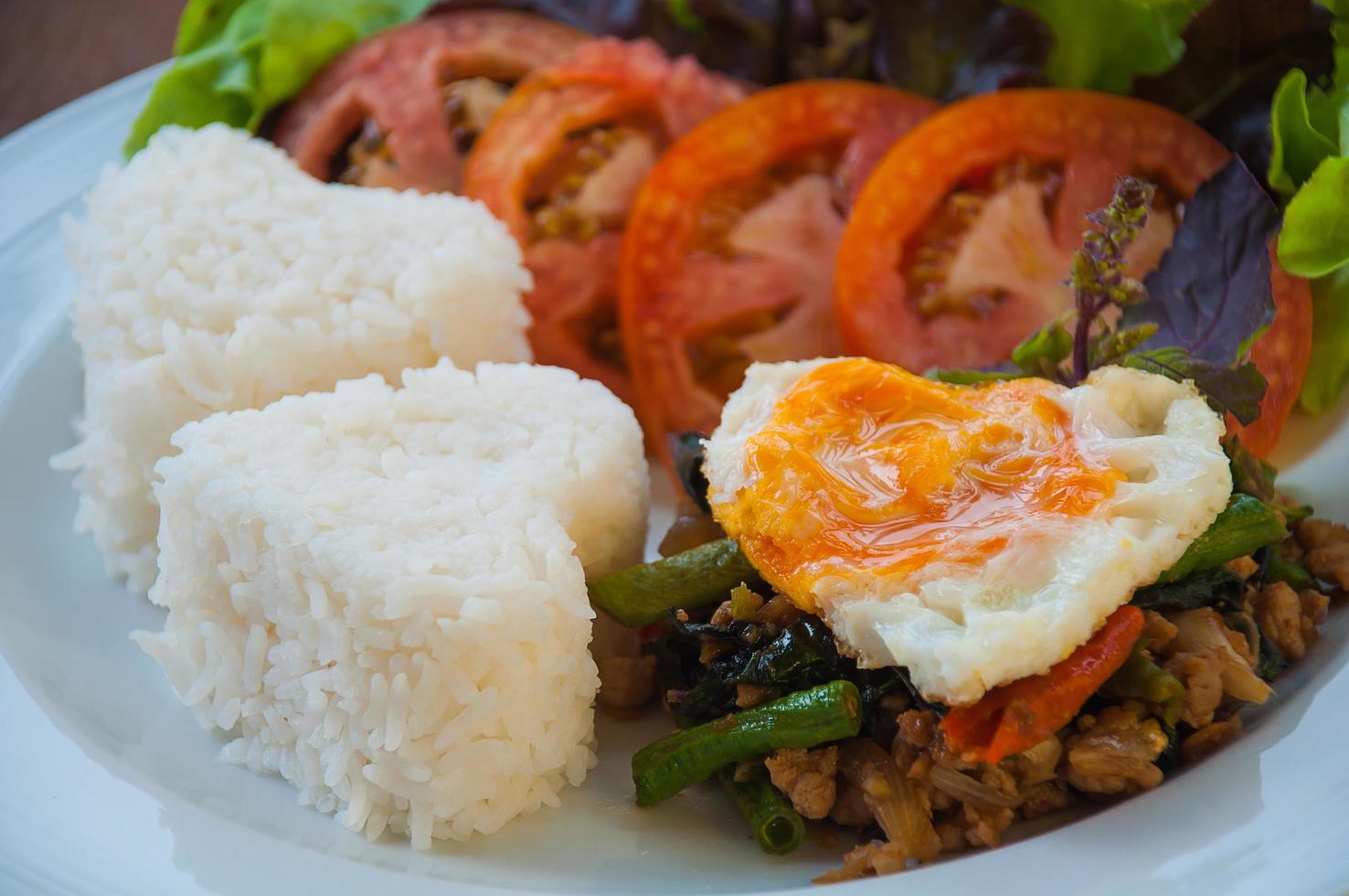 Rice topped with stir-fried pork and basil with egg, Thai style photo