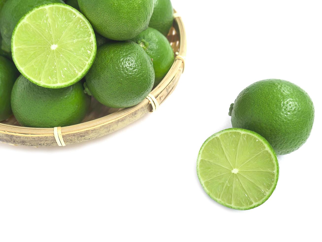 fresh green lime in the bamboo basket isolated on white background. photo