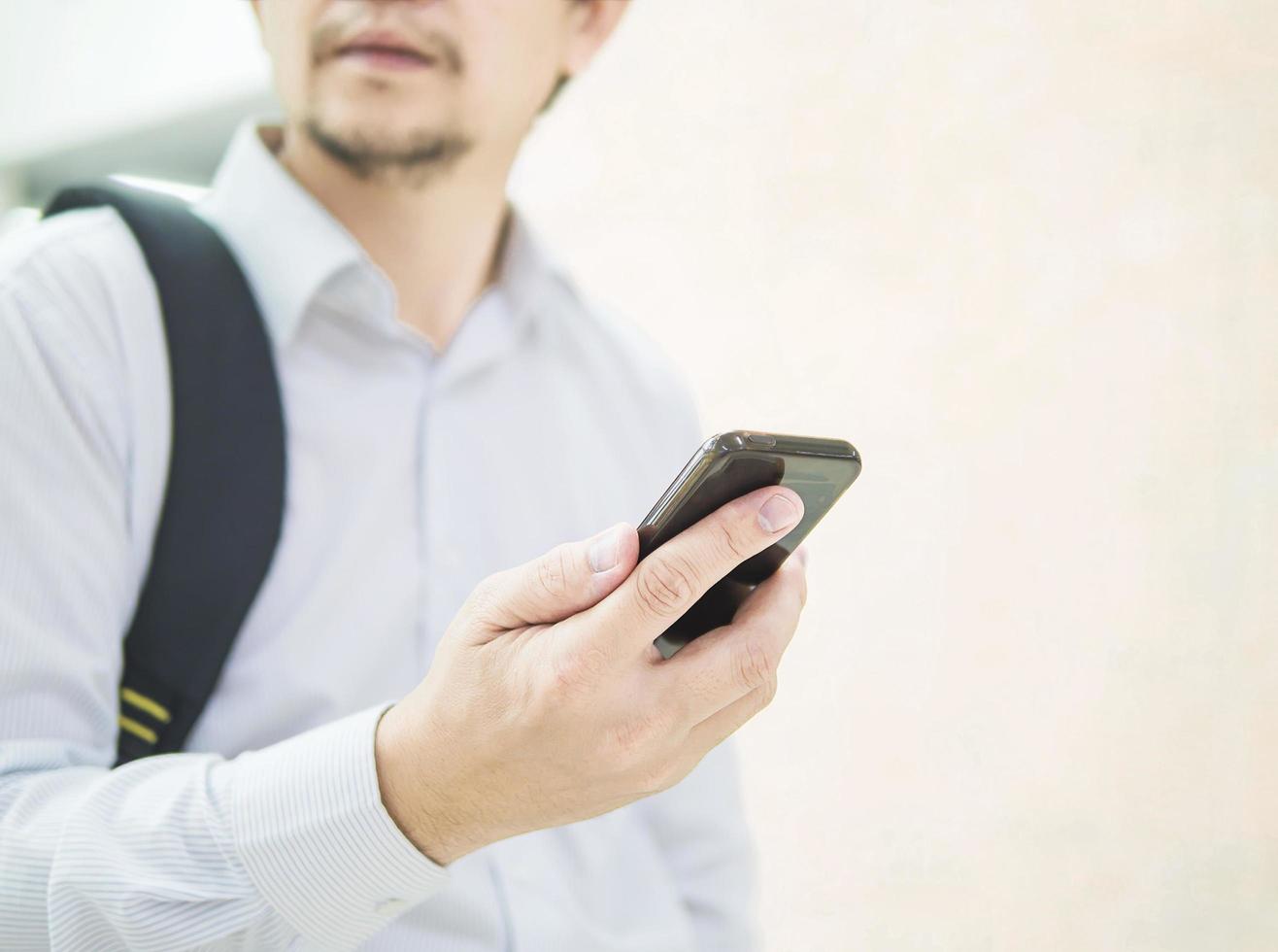 viajero de negocios usando teléfono móvil durante su viaje en la terminal del aeropuerto foto