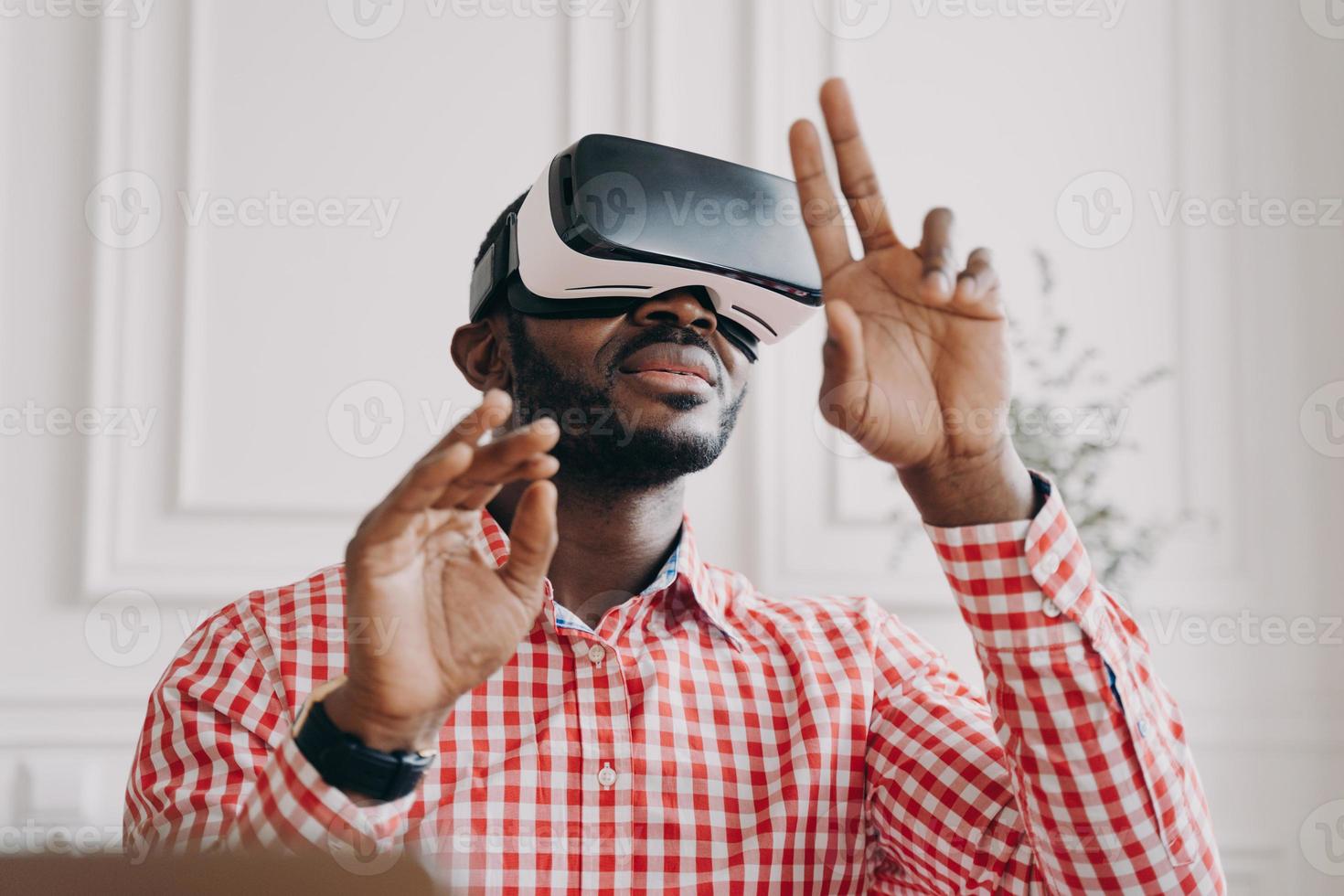 Black man in VR glasses experiencing 3D technology of augmented reality photo