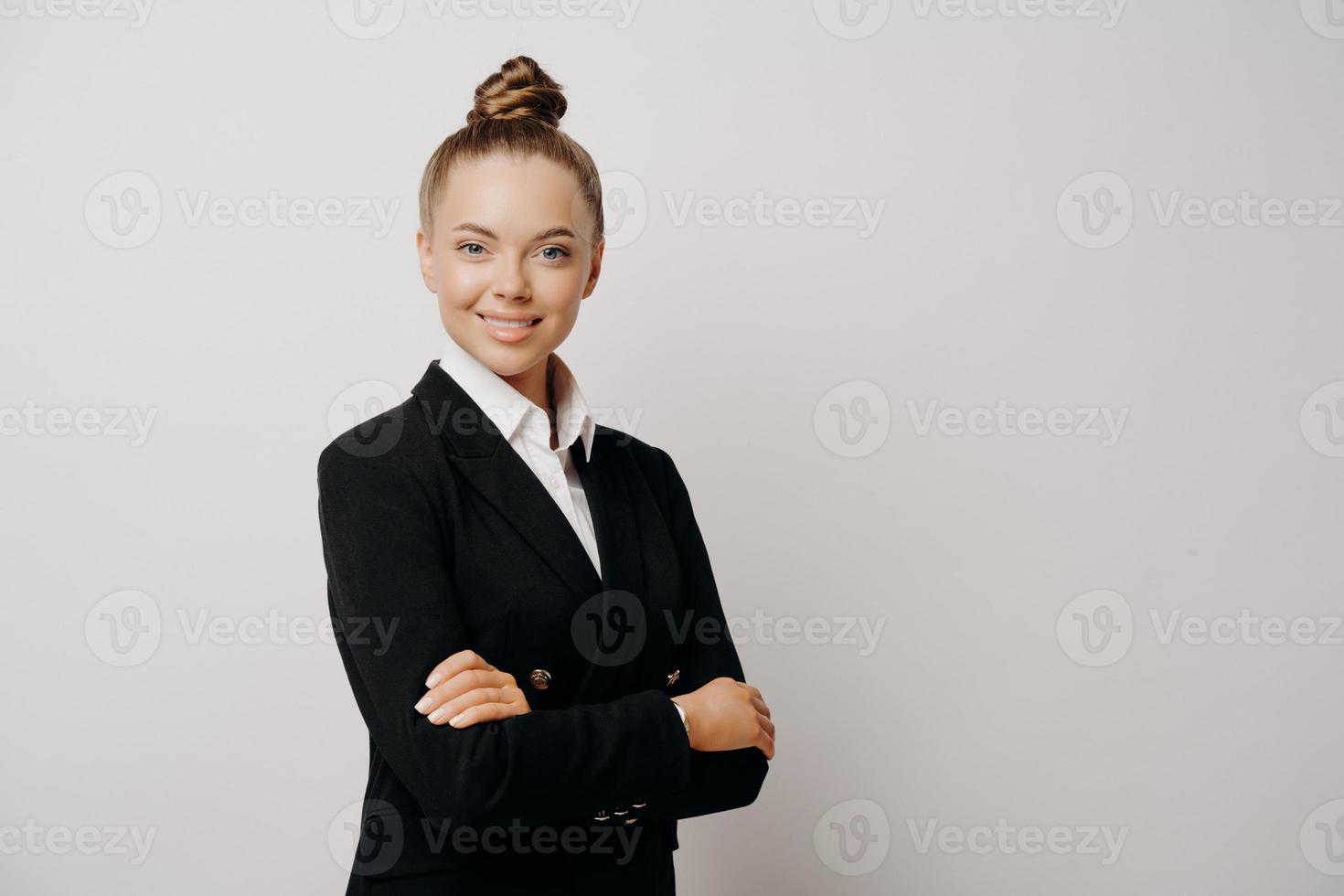 Woman executive in dark suit standing sideways photo