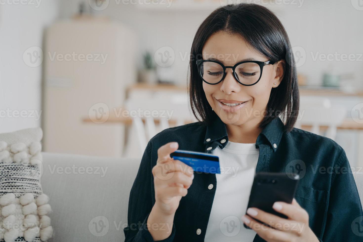 banca en línea. mujer con tarjeta de crédito bancaria, teléfono inteligente, pago en la aplicación de compras en casa foto