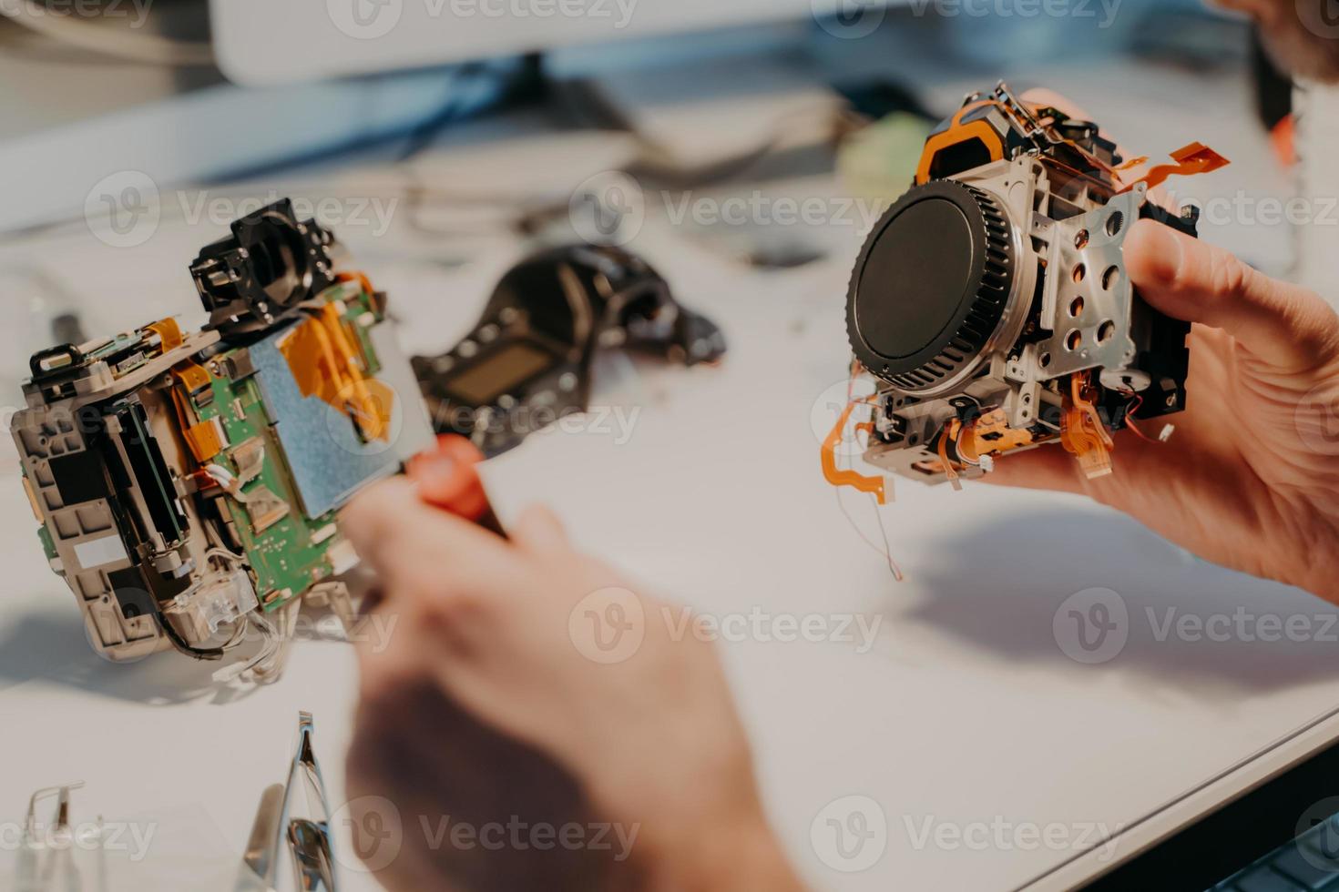 soporte de mantenimiento y servicio de reparación. el reparador irreconocible utiliza herramientas especiales, repara el dispositivo desmontado en el taller. fotografía de cerca. afición, ocupación foto