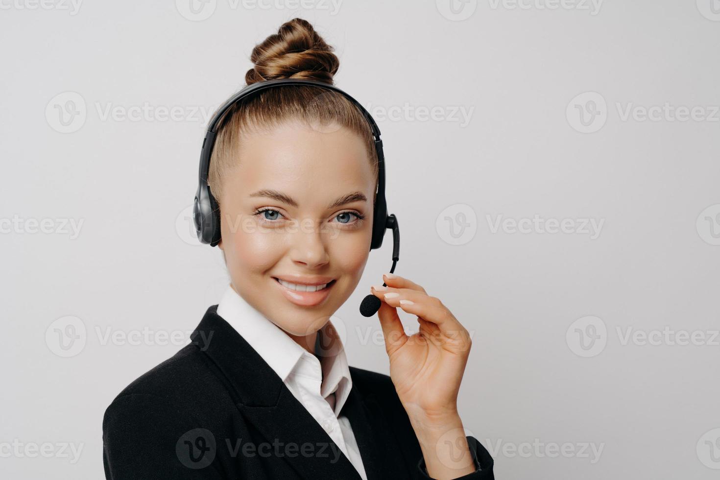 Female speaker with dark suit adjsting mic on headset photo
