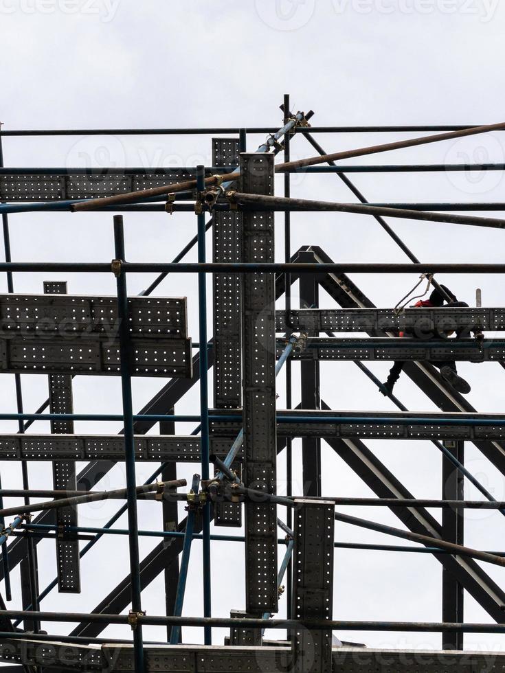 el trabajador de la construcción está trabajando en el andamio alto. foto